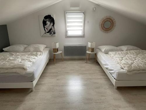 une chambre avec deux lits et une fenêtre dans l'établissement MAISON NOTRE DAME DE MONTS, à Notre-Dame-de-Monts