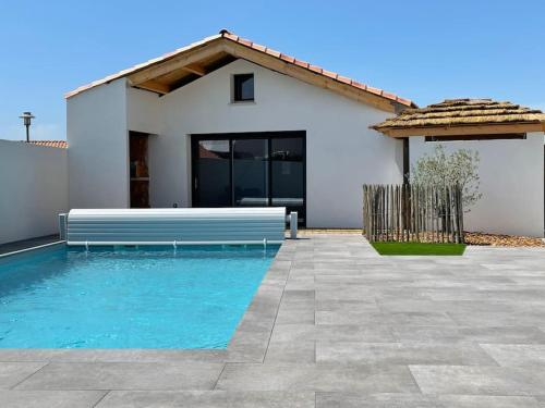une maison avec une piscine devant une maison dans l'établissement MAISON NOTRE DAME DE MONTS, à Notre-Dame-de-Monts