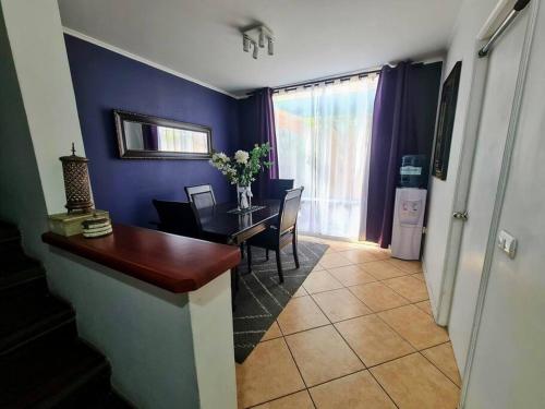 a dining room with a table and a blue wall at Casa en condominio jardines del norte Antofagasta. in Antofagasta