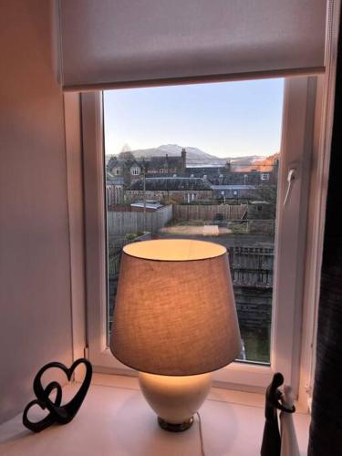 a lamp in front of a window with a view at Newly refurbished flat - Callander in Callander
