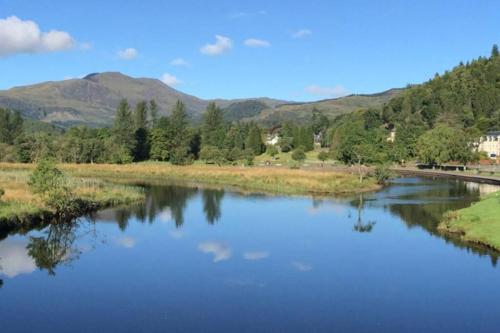 a view of a river with mountains in the background at Newly refurbished flat - Callander in Callander