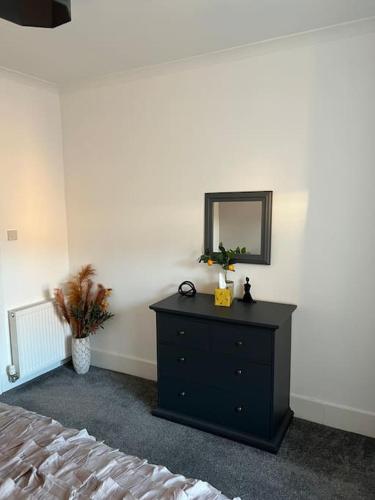 a bedroom with a dresser with a mirror and a bed at Newly refurbished flat - Callander in Callander