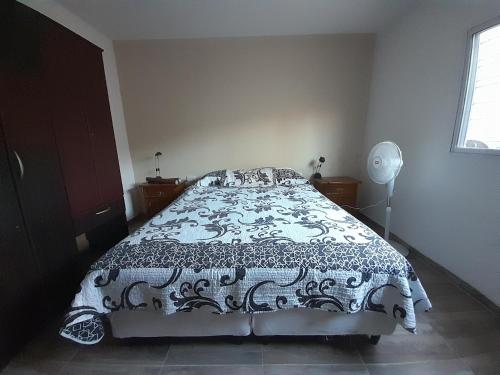 a bedroom with a bed with a black and white comforter at Casa Blend in Las Heras