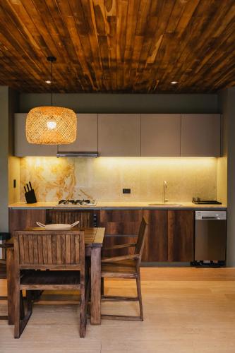 a kitchen with a wooden table and a wooden ceiling at Naio Hotel y Villas By OxoHotel in Palomino