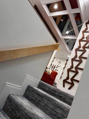 a staircase in a house with a red couch at 53 Luxury Rooms in Maynooth