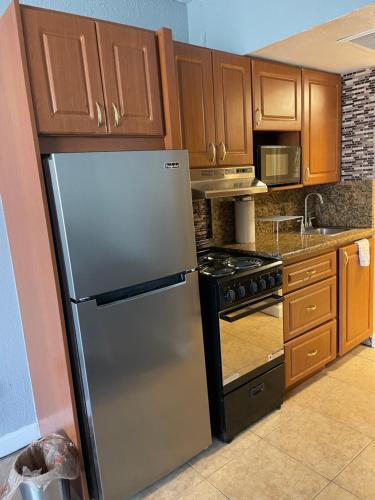 a kitchen with a stainless steel refrigerator and wooden cabinets at Marco Polo Beach Resort Condo with balcony in Sunny Isles Beach