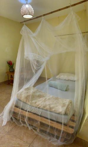 a bed covered in mosquito nets in a room at Gaia Eco Hub BnB in Fort Portal
