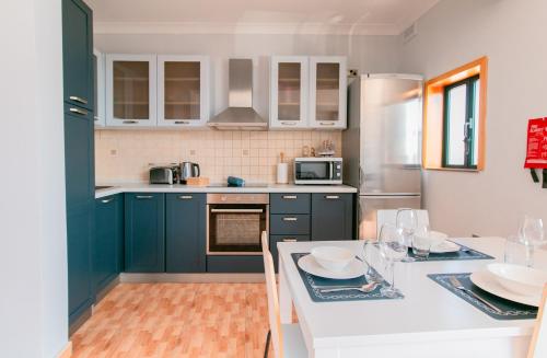 a kitchen with blue cabinets and a white counter top at Grand Harbour View in Birgu