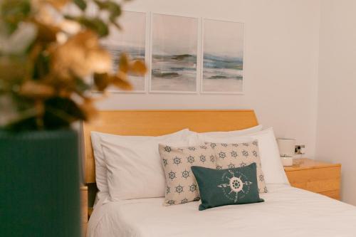 um quarto com uma cama com lençóis brancos e almofadas em Grand Harbour View em Birgu