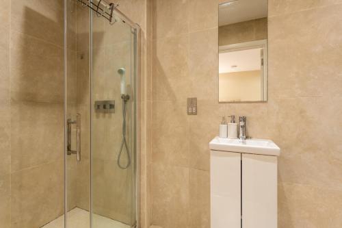 a bathroom with a shower and a sink and a mirror at Beautiful 2-Bed Apartment in London in London