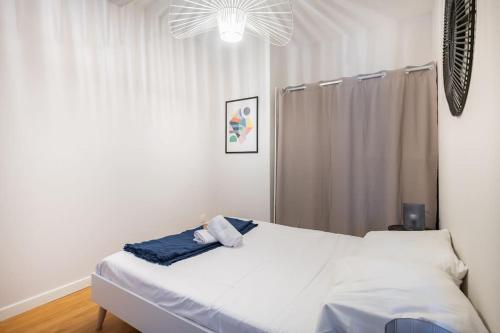 a bedroom with a white bed and a window at Le cocon de Vauban in Marseille