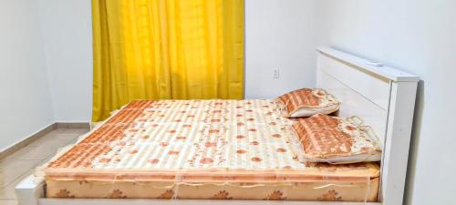 een bed met twee kussens in een kamer bij Kapowlito Real Estate Casa #3+4 Mon Plaisirweg in Paramaribo