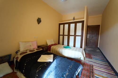 a bedroom with two beds and a window at ACHAHOUD CHEz LA BELLE FIBULLE in Aït Fars