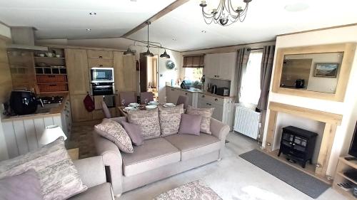 a living room with a couch and a fireplace at Binka - Luxury 40 x 14ft Lodge in Tain
