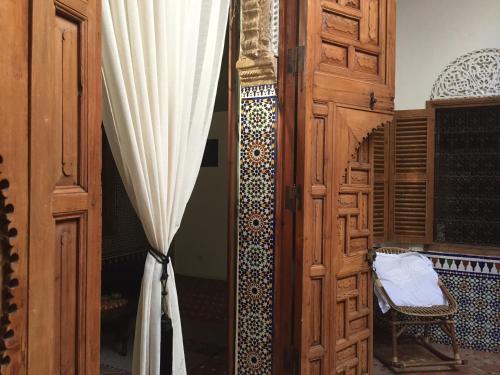 a window with a curtain next to a wooden door at Riad Marhaba in Rabat