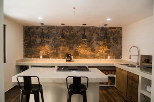 a kitchen with a sink and a counter with stools at El ciruelo in Teziutlán