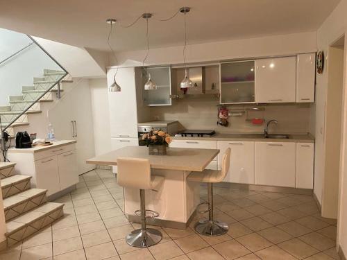 a kitchen with white cabinets and a table with chairs at Villetta familiare a Potenza Picena in Potenza Picena