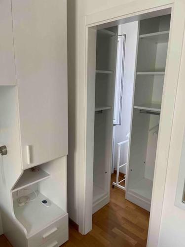 a white closet with white shelves and a window at Villetta familiare a Potenza Picena in Potenza Picena