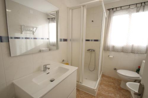 Baño blanco con lavabo y aseo en Apartamento Maria Paz Cambrils, en Cambrils