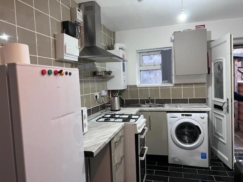 a kitchen with a refrigerator and a washing machine at Luxury 2 Bed Apartment in Manchester in Manchester