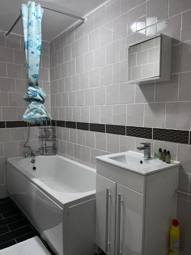 a white bathroom with a tub and a sink at Luxury 2 Bed Apartment in Manchester in Manchester