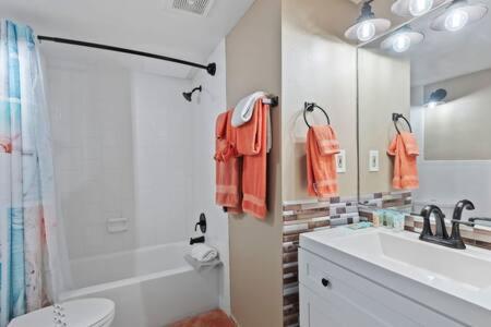 a bathroom with a sink and a toilet and a mirror at NEW Oceanside Inn 603 King Bed Ocean Views in Daytona Beach