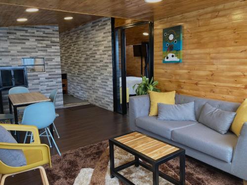 a living room with a couch and a table at ECO CABAÑAS EL ABUELO in La Calera