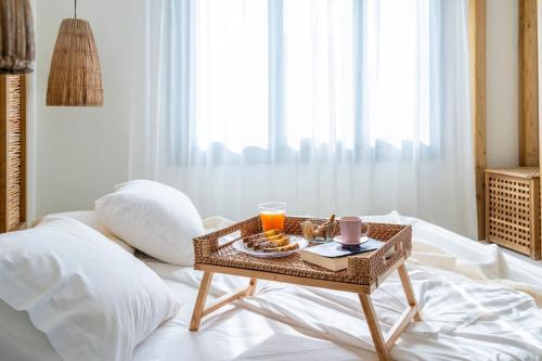 - Mesa de centro con bandeja de comida en la cama en Sirma Beach House, en Kimolos