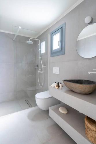 a white bathroom with a sink and a shower at Sirma Beach House in Kimolos