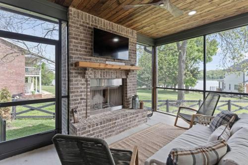 a living room with a brick fireplace with a tv at Basecamp Retreat TimsFordLake in Winchester