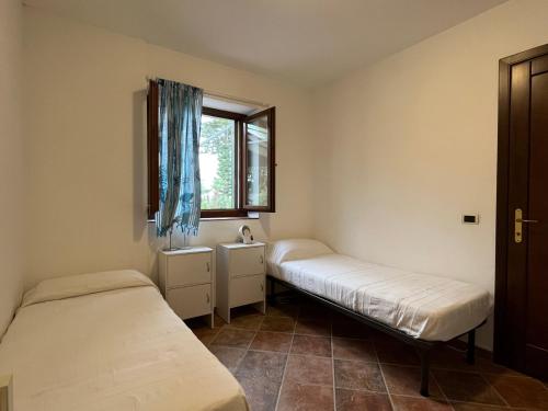 Il Giardino su Capo Caccia في ألغيرو: غرفة بسريرين ونافذة