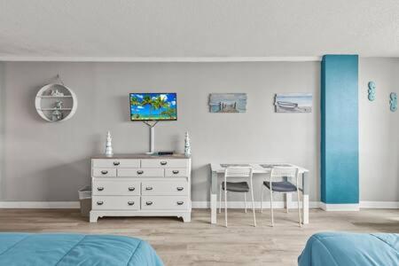 a bedroom with a bed and a dresser and a desk at Oceanside Inn 604 - Water Views, Beach Access Pool & Pool Bar in Daytona Beach