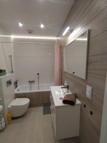 ein Badezimmer mit einem Waschbecken, einem WC und einer Badewanne in der Unterkunft Apartament Zacisze 3 modern in Częstochowa