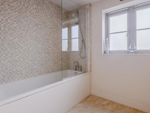 a bathroom with a tub and a window at 3 Bed in Burnham Deepdale KT045 in Burnham Deepdale