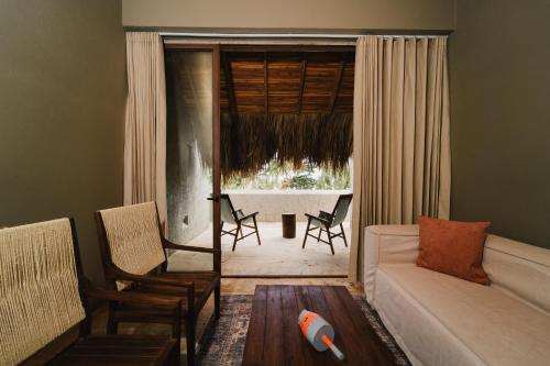 a living room with a couch and chairs and a window at Naio Hotel y Villas By OxoHotel in Palomino