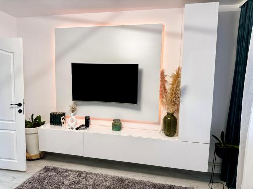 uma sala de estar com televisão numa parede branca em Modern 1 bedroom apartament em Turnu Măgurele