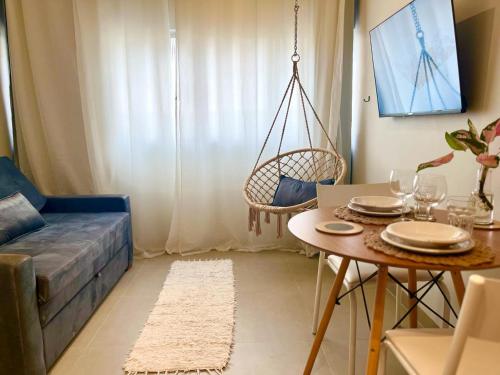 uma sala de estar com um sofá azul e uma mesa em Apartamento Glória no Rio de Janeiro