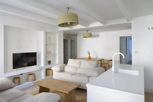 a white living room with a couch and a table at Luxury Houses La Mar de Bonita in Guardamar del Segura
