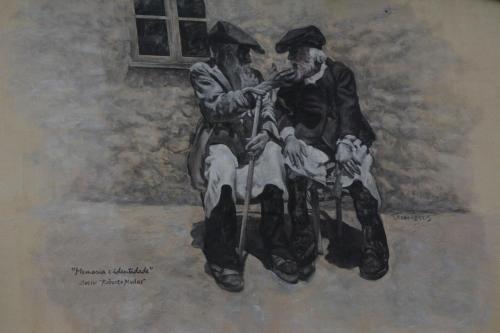 a painting of two men sitting next to each other at Sa domu 'eccia in Urzulei