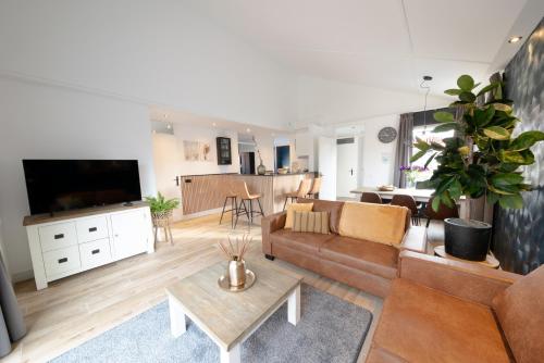 ein Wohnzimmer mit einem Sofa und einem TV in der Unterkunft Recreatiepark de Koornmolen in Zevenhuizen