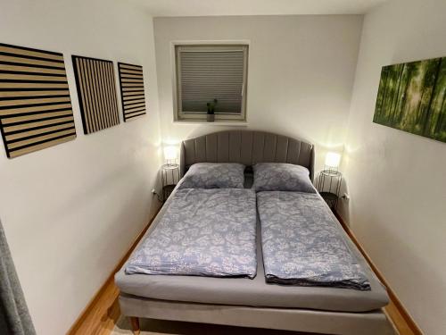 4*+ Maisonette-Apartment في بروخن: سرير في غرفة صغيرة بها مصباحين
