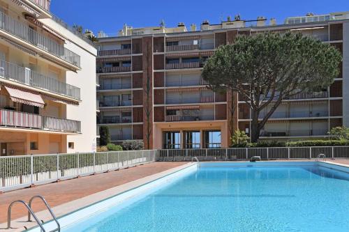 une piscine devant un grand immeuble d'appartements dans l'établissement Lovely studio with pool by the sea, à Roquebrune-Cap-Martin