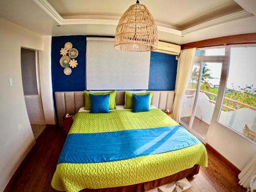 Un dormitorio con una cama azul y amarilla y una ventana en Suite Cielo, Discover the magic of Galapagos, en Puerto Baquerizo Moreno