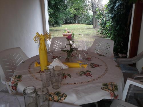 a table with a white table cloth and a yellow centerpiece at Nel's Casa Hostel A 15 minutos de Aeropuerto Ezeiza in Monte Grande