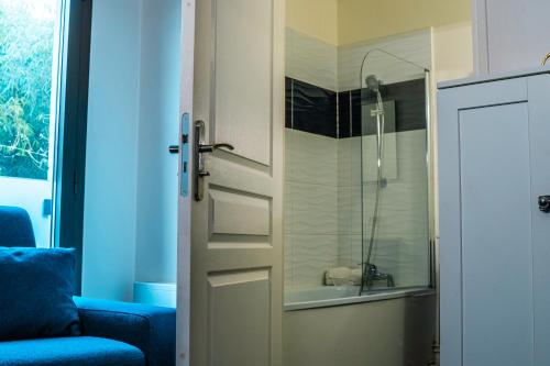 - une porte menant à une salle de bains pourvue d'une douche en verre dans l'établissement Studio Mignon proche de Paris et Disneyland, à Neuilly-sur-Marne
