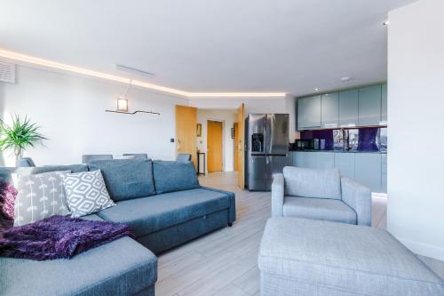 un soggiorno con divano blu e 2 sedie di High-Spec Penthouse Central *Free Parking Space* a Sheffield