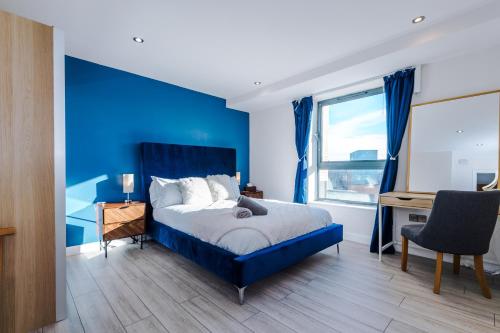 a blue bedroom with a bed and a desk at High-Spec Penthouse Central *Free Parking Space* in Sheffield