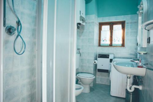 a bathroom with a toilet and a sink and a shower at Casa Franca trilocale in Argentera