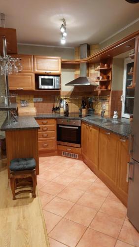 a large kitchen with wooden cabinets and a stove at Apartmán Gaidi in Zlín
