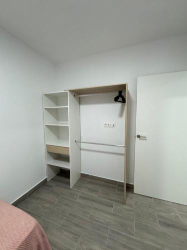 1 dormitorio con pared blanca y armario en NAUZAYARA 6, en La Frontera